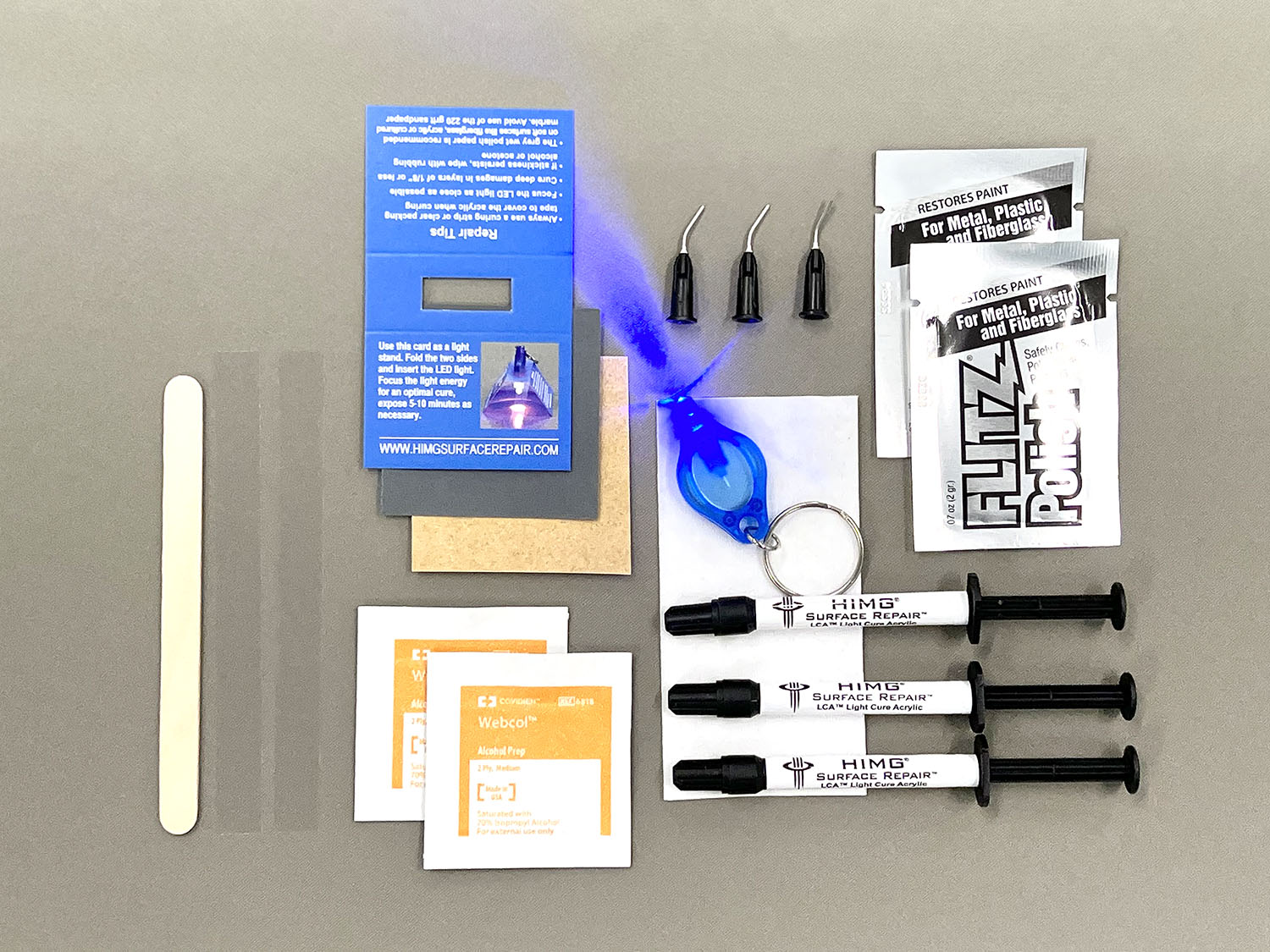 This kit includes:  • Three 1 gram syringes of Light Cure Acrylic™ in Grey, Whisper Grey and Thunder • 2 Packets of Flitz Polish Paste • 1 LED Curing Light • 1 LED Light Stand • Wood Application Tool • Non-Scratch Sandpaper • 2 curing strips • 3 micro tips • 2 Alcohol Prep Pads • Multi language repair instructions